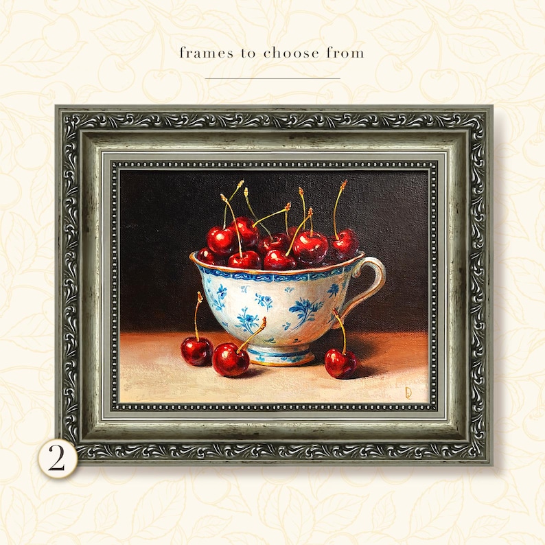Puede incluir: Pintura enmarcada de una taza de t&eacute; llena de cerezas. La taza de t&eacute; tiene un dise&ntilde;o floral azul y blanco. Las cerezas son de color rojo intenso. El marco es plateado con detalles ornamentados. El texto de la imagen dice "frames to choose from".