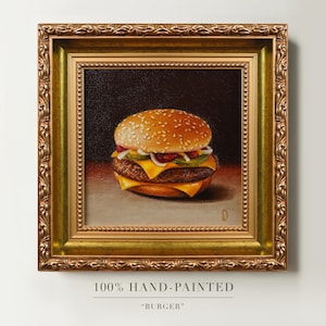 May include: An oil painting of a cheeseburger with a sesame seed bun, melted yellow cheese, and green pickles, set against a dark background. The artwork is encased in an ornate, metallic gold frame with intricate carved detailing and a beaded inner edge.