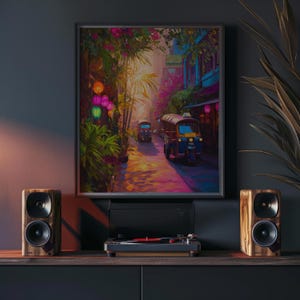 May include: A framed art print showing a colourful street scene with tuk-tuks, greenery, and lights. The artwork is displayed above a turntable and two wooden speakers, creating a home entertainment setup.