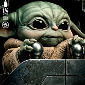 May include: A detailed, green-skinned figure with large black eyes, reminiscent of a popular character. The figure is seated in a metallic, textured cockpit, holding two silver spheres. The image includes text that reads "1/4 SCALE RESIN & FDM" and "SW3D PATREON".