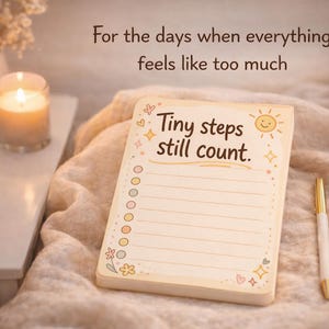 K&ouml;nnte beinhalten: Ein rechteckiger Notizblock mit cremefarbenem Hintergrund, der den Text "Tiny steps still count." und eine Liste mit kreisf&ouml;rmigen K&auml;stchen enth&auml;lt. Der Block ist mit kleinen Sonnen-, Stern- und Blumenmotiven verziert und liegt neben einem gold-wei&szlig;en Stift.