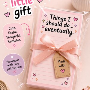 May include: A stack of light pink lined note paper wrapped in clear plastic with a light pink satin ribbon tied in a bow. A small brown kraft paper tag attached to the ribbon reads Made with a heart icon. The top sheet says Things I should do... eventually.