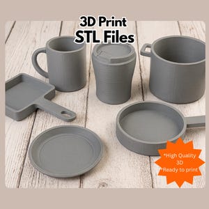 May include: A collection of gray 3D-printed kitchenware, including a mug, a travel cup, a saucepan, a frying pan, a plate, and a small square pan. The text "3D Print STL Files" is at the top. A starburst graphic says "High Quality 3D Ready to print."