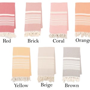 May include: Set of ten Turkish cotton towels in various colors, including red, brick, coral, orange, yellow, beige, and brown. Each towel features a white stripe pattern and fringe trim.