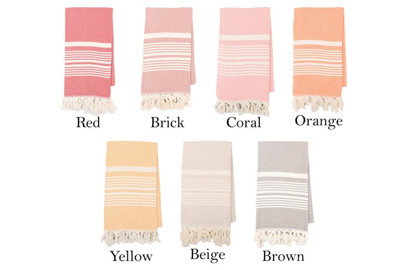 May include: Set of ten Turkish cotton towels in various colors, including red, brick, coral, orange, yellow, beige, and brown. Each towel features a white stripe pattern and fringe trim.