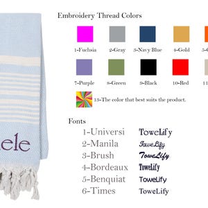 May include: A light blue beach towel with white stripes and a white fringe. The towel has the name "Michele" embroidered on it in purple thread. The image also shows a color chart of embroidery thread colors and a list of fonts.