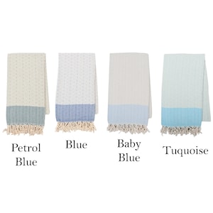 May include: Six folded cotton towels in various colors: navy, petrol blue, blue, baby blue, turquoise, and mint. Each towel has a contrasting color border and fringe.
