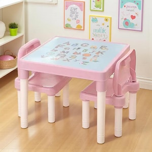 May include: A pink children's table and chair set. The table has a light blue top with the alphabet printed on it. The legs are white. The chair is attached to the table and has a pink seat and back. The set is designed for young children.