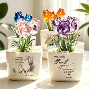 May include: Four square white ceramic pots containing glass tulip flowers in various colours. The pots feature printed text and illustrations, including Winnie the Pooh characters, thank you messages, and names like Mrs. Smith and Brenda.