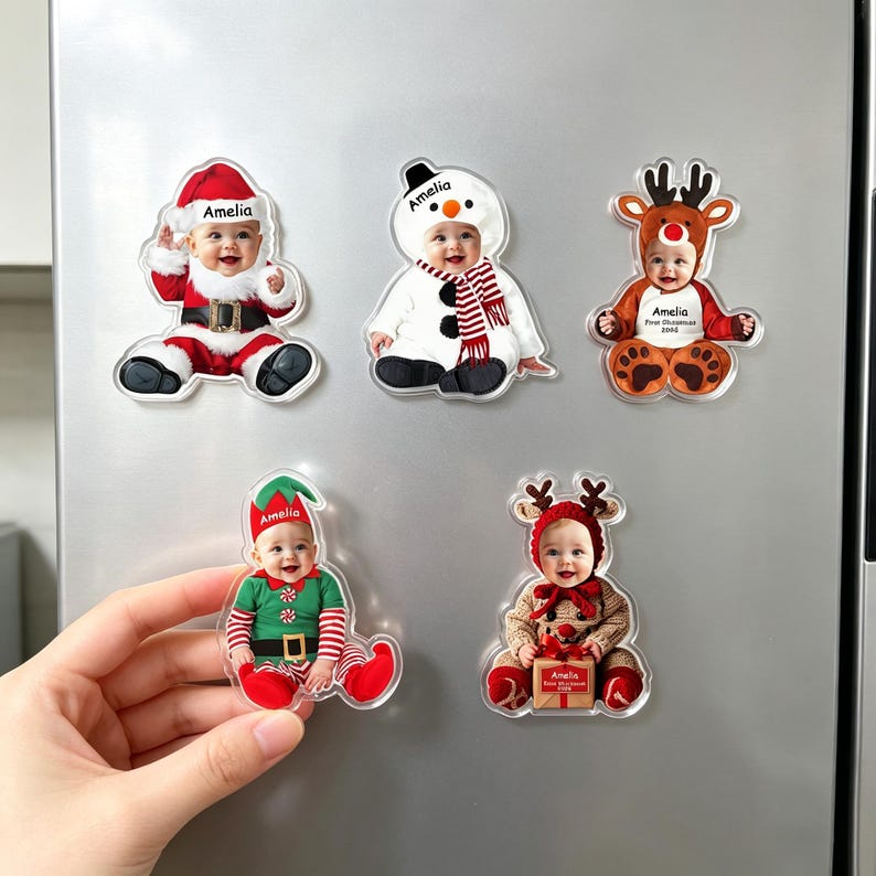 May include: Five custom acrylic magnets featuring a baby dressed in various holiday costumes including Santa Claus, a snowman, a reindeer, an elf, and a festive outfit with a gift. Each magnet displays the name Amelia printed on the clothing.