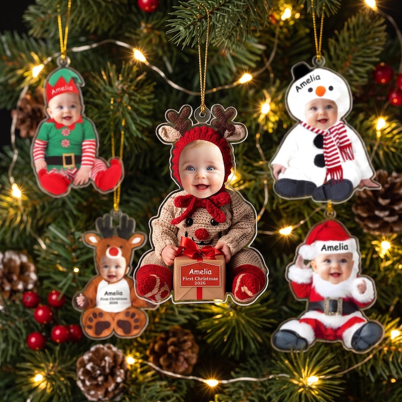 May include: Five personalized Christmas ornaments featuring photos of a baby in various costumes including an elf, a reindeer, a snowman, and Santa Claus. Each ornament displays the name Amelia and the text First Christmas 2026 on a gift box.
