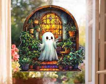 May include: A decorative hanging ornament featuring a cartoon ghost watering plants in a greenhouse setting. The ghost is white with a friendly expression. The background includes a stained-glass window and various potted plants.