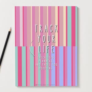 Puede incluir: Un cuaderno con un diseño de rayas coloridas en rosa, morado y turquesa. El texto "TRACK YOUR LIFE" se muestra en la portada, junto con las palabras "CHECKLISTS, PLANNERS, AND PAGES FOR DOODLING". Un lápiz está a la izquierda.