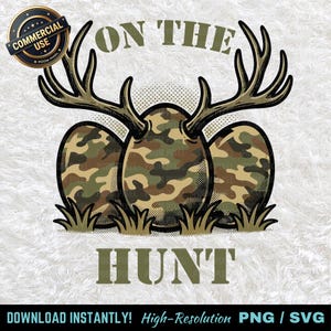 May include: A digital graphic featuring three egg-shaped objects with a camouflage pattern, topped with deer antlers. The text "ON THE HUNT" is displayed in a green, stencil-like font. A "COMMERCIAL USE" badge is in the upper left.