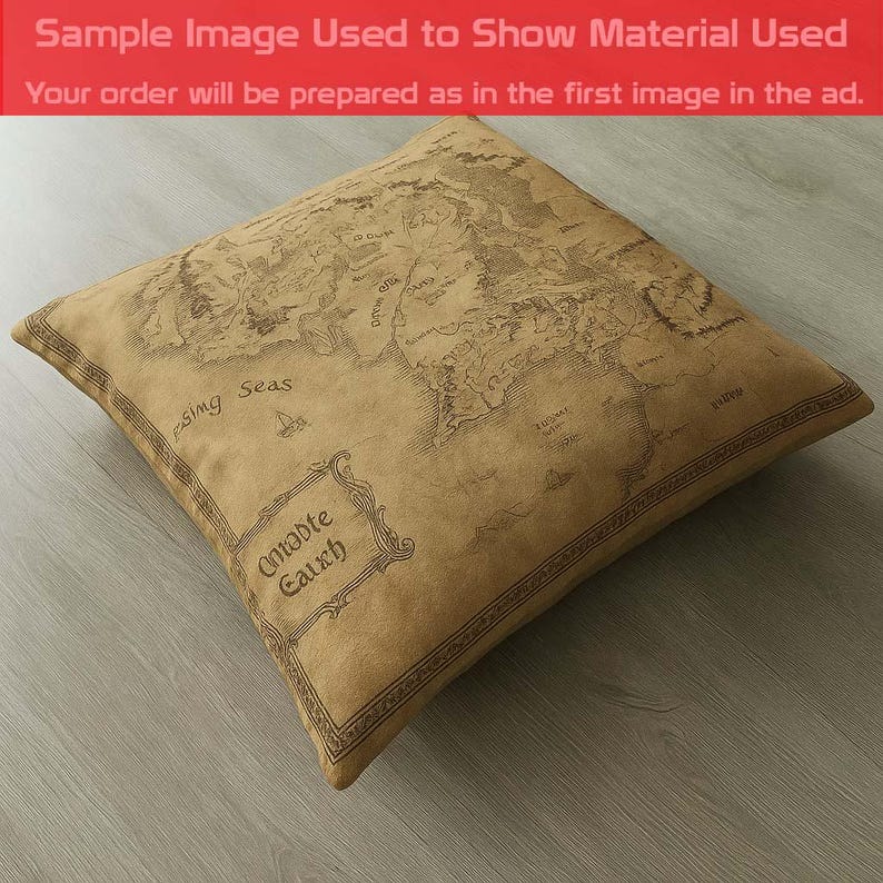 May include: Square pillow with a map design in shades of brown. The pillow features a detailed map with text including "Middle Earth" and "Passing Seas". The pillow is on a light gray surface. The text "Sample Image Used to Show Material Used" is visible.