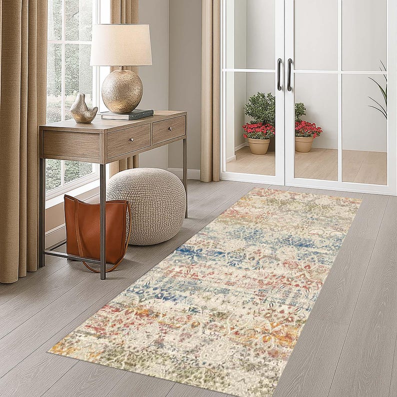 May include: A rectangular area rug with a distressed, vintage-inspired design. The rug features a mix of colors, including cream, blue, red, and gold. It is placed on a wooden floor in a hallway setting, adding a decorative element to the space.