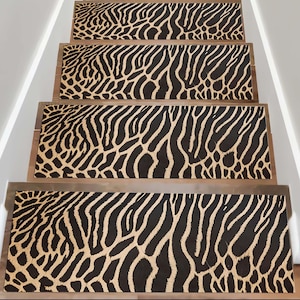 Pode incluir: Degraus de escada com um padrão de listras de zebra em preto e bege. Os degraus retangulares são instalados em escadas de madeira. O padrão de zebra cobre toda a superfície de cada degrau, criando um visual arrojado e decorativo para a escada.