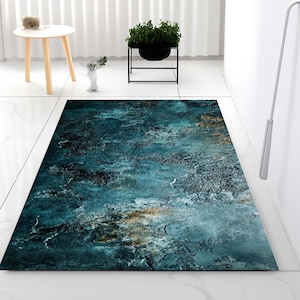 Può includere: Un tappeto rettangolare caratterizzato da un motivo astratto in blu scuro e verde ottanio, con texture screziate e sottili accenni di toni terra, marrone e oro, che ricorda una superficie in pietra usurata dall'aspetto invecchiato.