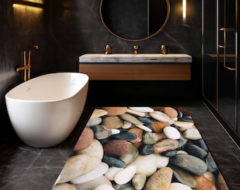 Può includere: Un bagno moderno con una vasca ovale bianca, un mobile con specchio rotondo e un tappetino da bagno rettangolare. Il tappetino da bagno presenta un motivo di pietre lisce e colorate nei toni del marrone, grigio, bianco e beige. Il bagno ha pareti scure e accessori dorati.