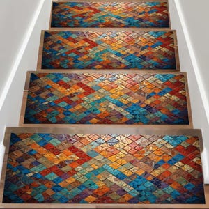 Puede incluir: Peldaños de escalera con un colorido patrón de mosaico. Las huellas presentan un diseño geométrico con una mezcla de formas de diamante naranja, azul, rojo y amarillo. Las huellas están colocadas en escaleras de madera con paredes blancas.