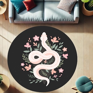 Könnte beinhalten: Ein runder, schwarzer Teppich mit einem weißen und rosa Schlangenmuster, umgeben von rosa Blumen und grünen Blättern. Das Design des Teppichs ist ein dekoratives Blumen- und Fauna-Muster.