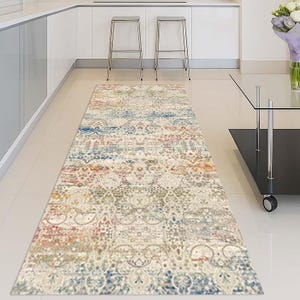 May include: A rectangular runner rug with a distressed, vintage-inspired design. The rug features a mix of colors including cream, blue, red, and gold. The pattern includes floral and geometric elements, suitable for a hallway or kitchen.