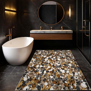 Puede incluir: Un baño moderno con una bañera ovalada blanca, un tocador de madera con encimera de mármol y una alfombra de baño con diseño de guijarros. Las paredes oscuras y un espejo redondo complementan los accesorios dorados, creando un ambiente lujoso.