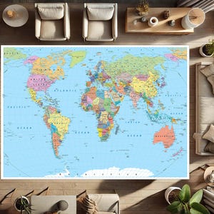 Puede incluir: Una gran alfombra con un mapa del mundo colorido con detalles geográficos. El mapa muestra continentes, países y océanos en varios colores sobre un fondo azul claro. La alfombra es rectangular y está colocada sobre un suelo de madera.