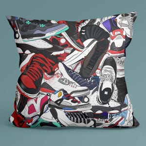May include: A square pillow featuring a colorful collage of sneakers in various styles and colors. The design includes red, black, white, and blue shoes, creating a vibrant and eye-catching pattern. The pillow is a decorative item for home decor.