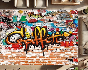 Op de afbeelding: Een kleurrijk tapijt met een graffiti-ontwerp met het woord "Graffiti" in vette letters. Het tapijt heeft een bakstenen achtergrond en bevat verschillende spuitbussen, cartoonfiguren en het woord "Muziek".