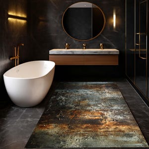 Könnte beinhalten: Ein modernes Badezimmer mit einer weißen ovalen Badewanne, einem Holzwaschtisch mit Marmorplatte und einem großen runden Spiegel. Ein rechteckiger Teppich mit einem verwitterten, rostigen Metalldesign liegt auf dem Boden. Die Wände sind dunkelgrau.