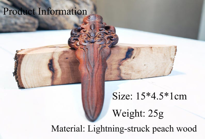 May include: A wooden carving in the shape of a dagger with intricate details. The carving is made from lightning-struck peach wood and measures 15 inches by 4.5 inches by 1 inch. It weighs 25 grams.
