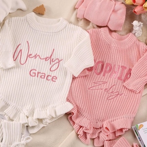 May include: Two long-sleeved knitted baby rompers with ruffled hems. One romper is white with the embroidered name Wendy Grace in pink, and the other is pink with the embroidered name Sophia in a darker pink script and block lettering.