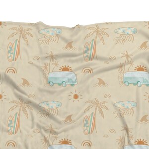 May include: A beige fabric with a repeating pattern of palm trees, surfboards, and vintage vans. The pattern is in shades of blue, orange, and brown.