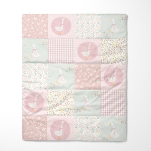 May include: A patchwork quilt with a repeating pattern of pink, white, and light green squares. Each square has a different floral or gingham design, with circular patches of a goose wearing a pink bow.