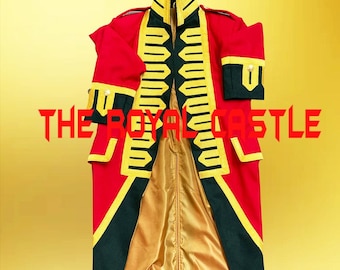 May include: A red military-style coat featuring dark green lapels and cuffs, accented with yellow braided trim and gold-tone buttons. The interior is lined with gold satin fabric. The text THE ROYAL CASTLE is printed in red across the center.