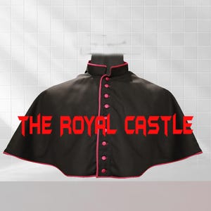 May include: Black cape with pink trim and buttons. The cape has a high collar and a button-up front. The text "THE ROYAL CASTLE" is displayed in red across the bottom of the cape. The cape is likely part of a costume or ceremonial garment.