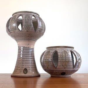 May include: A set of three ceramic mugs with a speckled, matte finish. The mugs are in shades of cream, light gray, and dark gray. Each mug has a simple, minimalist design, perfect for coffee or tea.