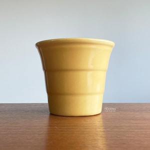 May include: A set of three ceramic mugs with a speckled, matte finish. The mugs are in shades of cream, light gray, and dark gray. Each mug has a simple, minimalist design, perfect for coffee or tea.