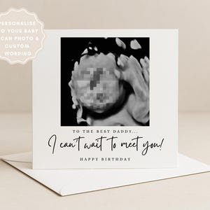 May include: A square white greeting card featuring a black and white baby ultrasound image in the centre. Below the image, the text reads: TO THE BEST DADDY... I can't wait to meet you! HAPPY BIRTHDAY. A matching white envelope sits underneath the card.