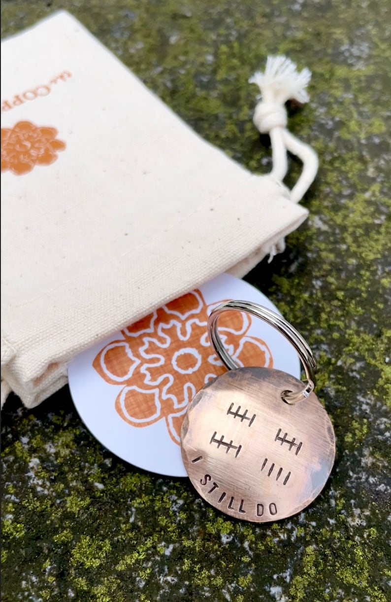 Peut inclure: Un porte-cl&eacute;s en cuivre avec les mots "I Still Do" grav&eacute;s dessus. Le porte-cl&eacute;s comporte une s&eacute;rie de lignes verticales repr&eacute;sentant des ann&eacute;es de mariage.