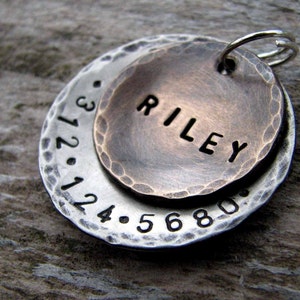 1" Aluminum disc hand stamped with a phone number is behind a 3/4" pet tag stamped with the name "Riley" . Tag hangs from a small split ring.