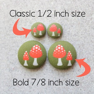 May include: Two sizes of fabric buttons with a mushroom design. The smaller buttons are 1/2 inch and the larger buttons are 7/8 inch. The buttons are green with red and white mushrooms.