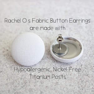 May include: A pair of white fabric button earrings with hypoallergenic, nickel-free titanium posts.  Rachel O s Fabric Button Earrings are made with.