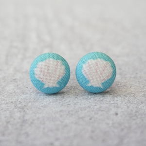 May include: A pair of blue fabric stud earrings with a white seashell design.