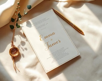 Puede incluir: Una tarjeta de invitación de boda rectangular de color crema con los nombres Emma & James impresos en dorado, acompañada de un bolígrafo dorado y una ramita con un sello de cera dorado, sobre una tela color crema.