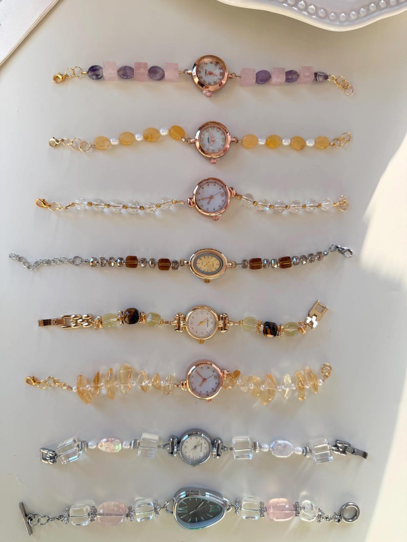 Pu&ograve; includere: Collezione di orologi da donna con braccialetti di pietre preziose e perline. I quadranti sono rotondi o ovali, in metallo dorato o argentato. I braccialetti presentano quarzo rosa, citrino e perline di cristallo trasparente.