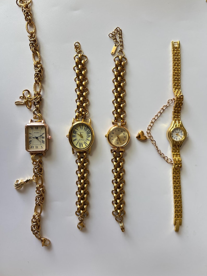 Puede incluir: Cuatro relojes de pulsera de tono dorado con diferentes estilos de correas. Los relojes tienen car&aacute;tulas redondas con marcas de n&uacute;meros romanos y manecillas de tono dorado.