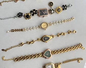 Könnte beinhalten: Sechs goldfarbene Armbanduhren mit verschiedenen Stilen von Zifferblättern und Armbändern. Die Armbänder verfügen über verschiedene dekorative Elemente, darunter Perlen, Blumen und Herzen.