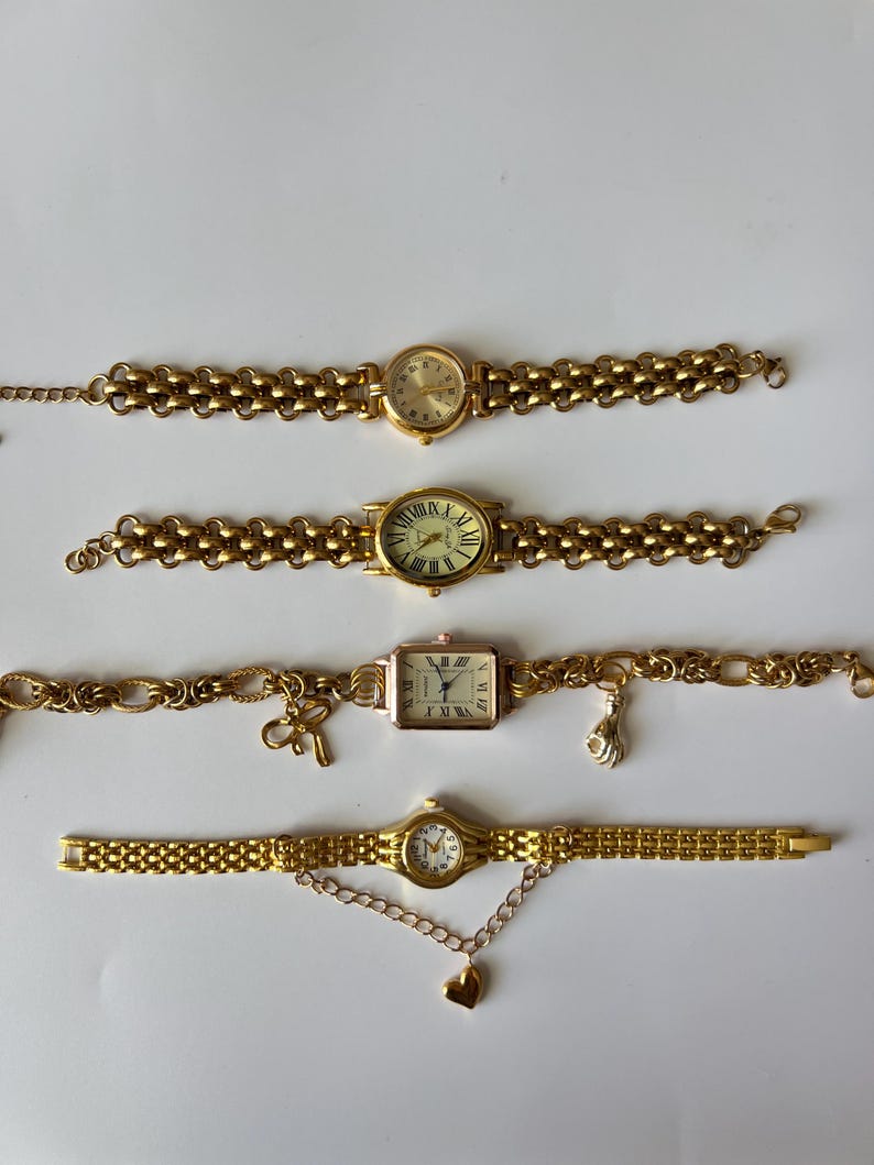 Puede incluir: Cuatro relojes de pulsera de tono dorado con diferentes estilos de esferas y correas. Las correas est&aacute;n hechas de cadenas de metal enlazadas.